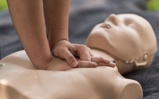 Closeup of someone performing CPR on a training dummy