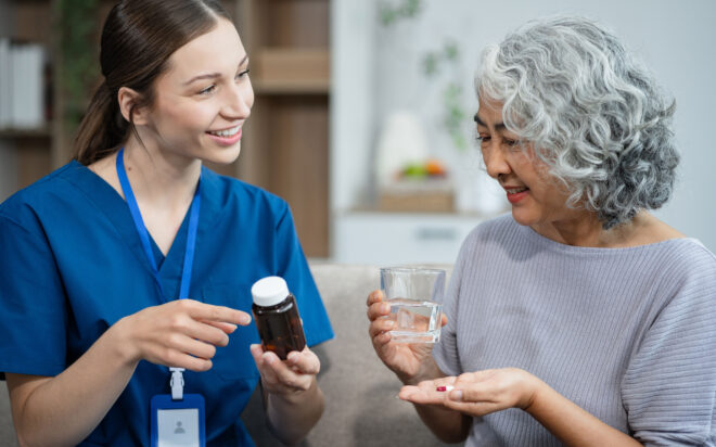 Nurse discussing medication with elderly patient in a home care setting