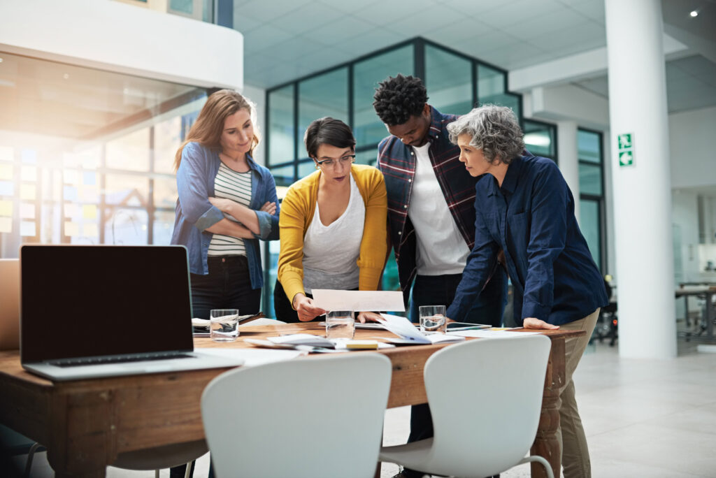 Diverse group of businesspeople looking at something over a conference table