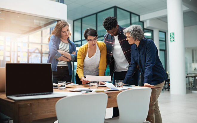 Diverse group of businesspeople looking at something over a conference table